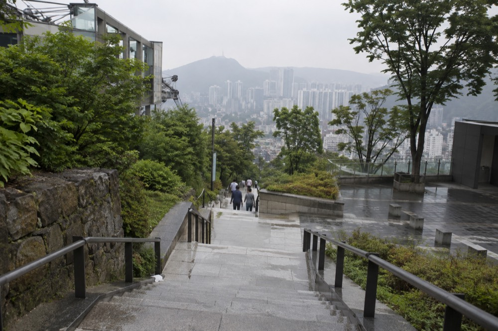 Paved walkway and stairs on the Namsan summit leading toward the tower plaza