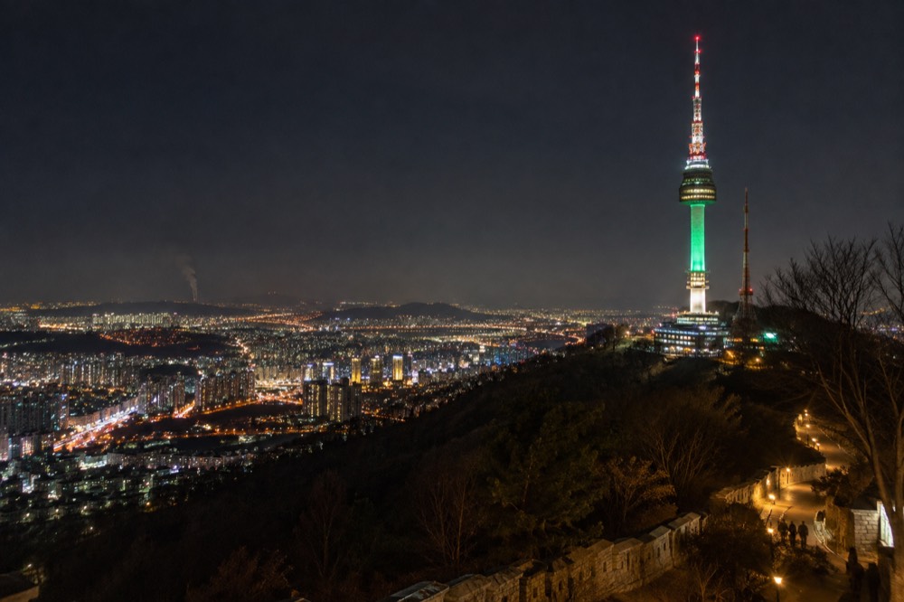 Seoul's city lights spread out beneath the illuminated N Seoul Tower after dark