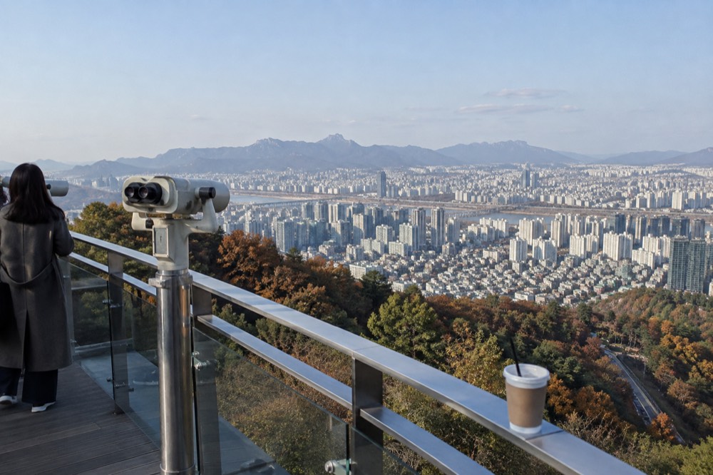 View over Seoul rooftops and distant mountains from a terrace on Namsan