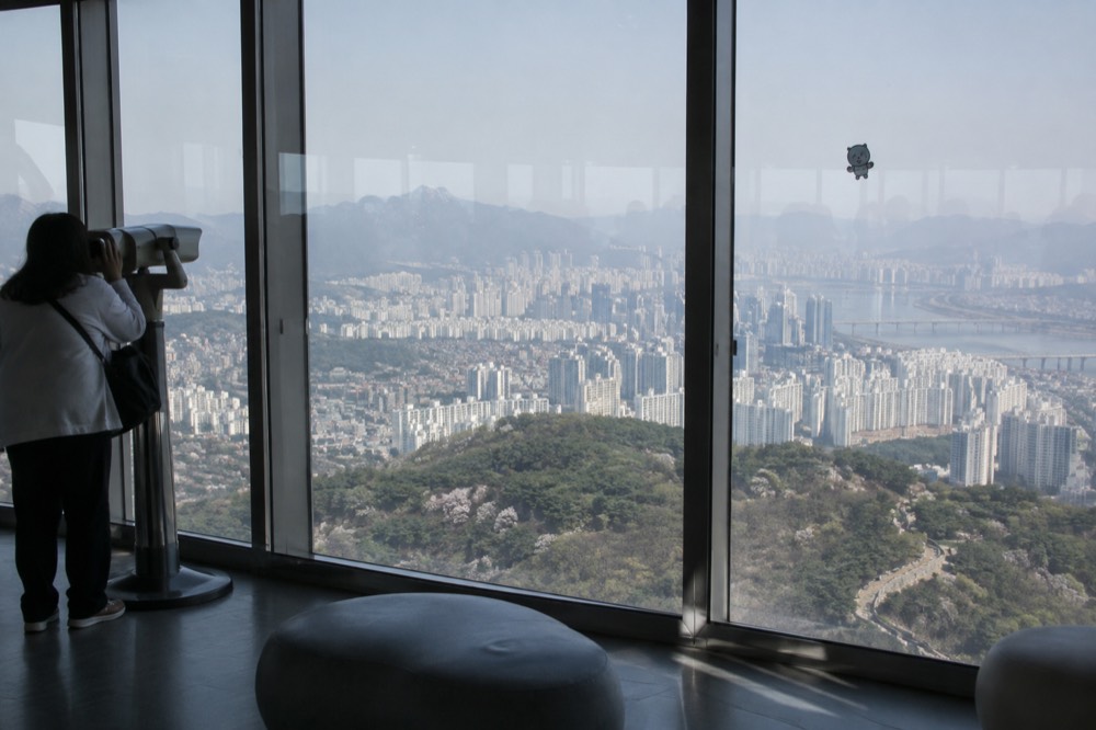 Observation deck interior of N Seoul Tower with floor-to-ceiling windows overlooking Seoul