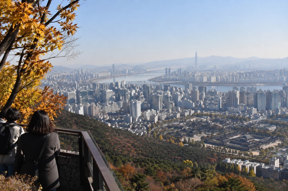 Panoramic city view from an elevated terrace with a river crossing the urban sprawl