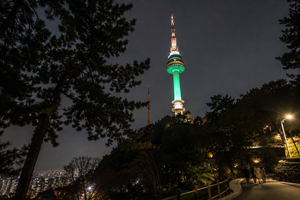 N Seoul Tower lit up at night above the city lights of Seoul