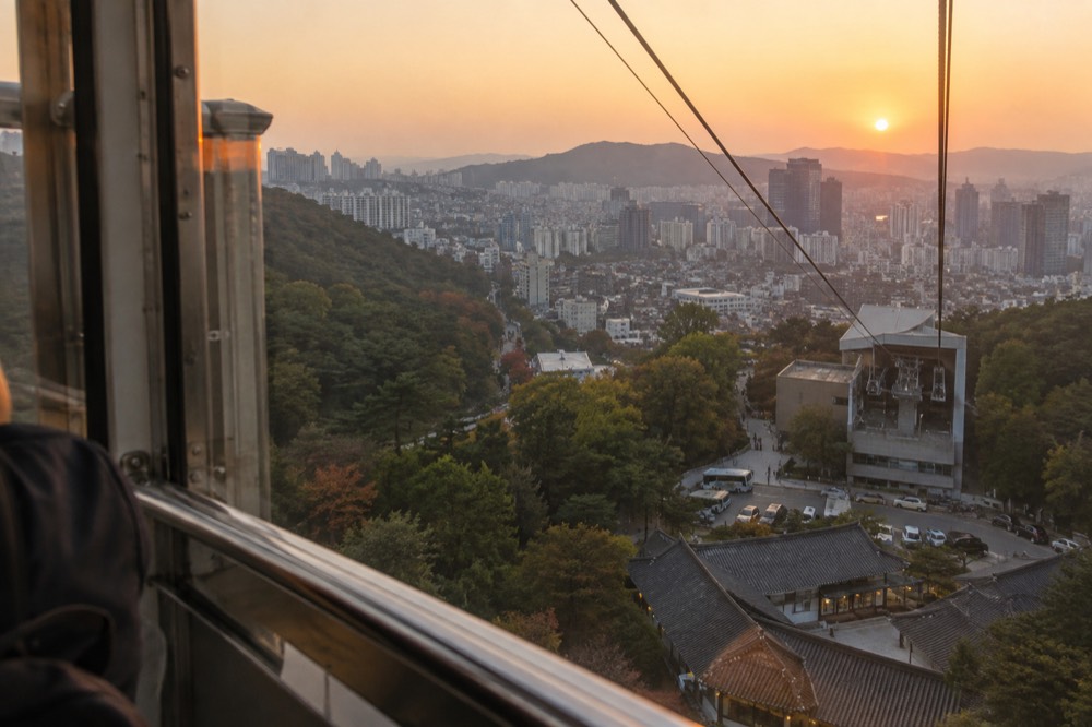 View from a cable car cabin over rooftops of central Seoul during the ascent