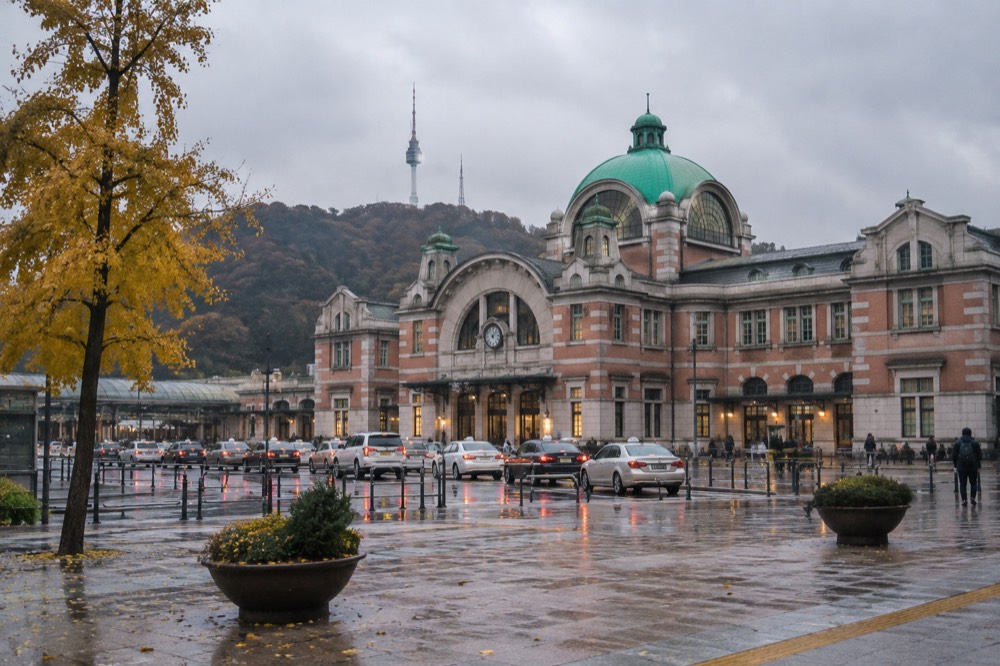 Seoul Station building with the wooded slope of Namsan rising behind it