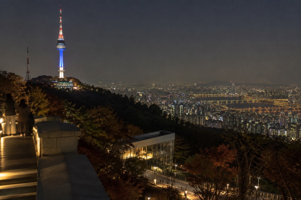 Seoul city lights spreading out below the illuminated N Seoul Tower on a clear night