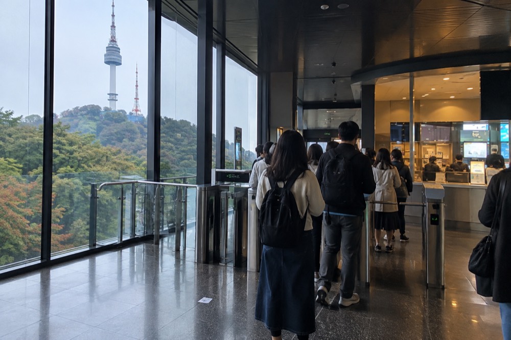 Ticket counter and turnstiles at an attraction entrance with visitors waiting