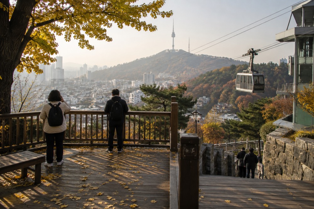 A timber deck viewing platform on a Namsan trail overlooking Seoul rooftops