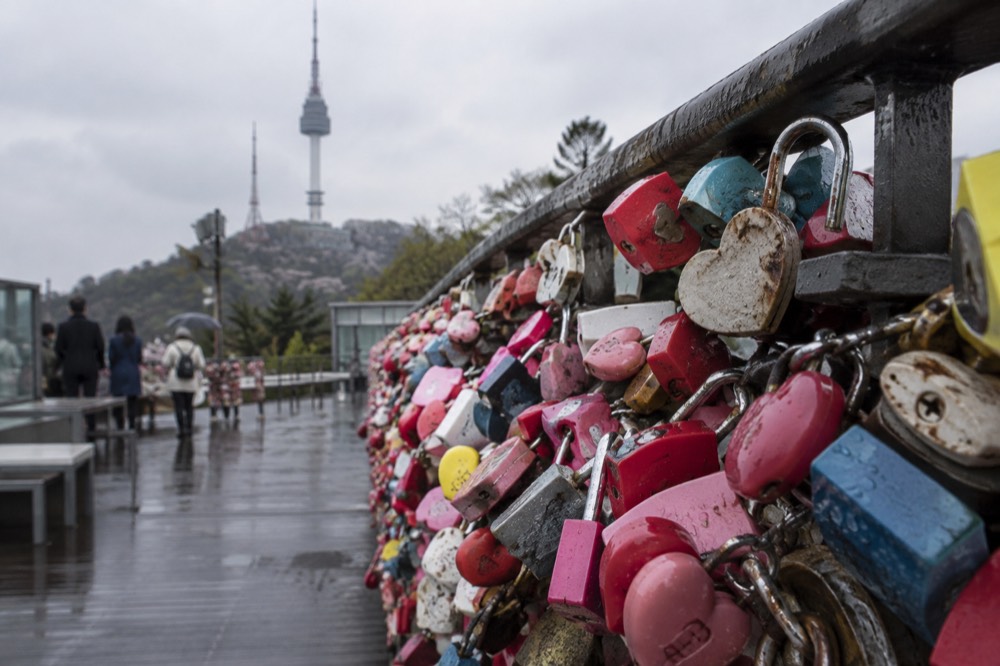 Railings covered with padlocks on a terrace near the tower base
