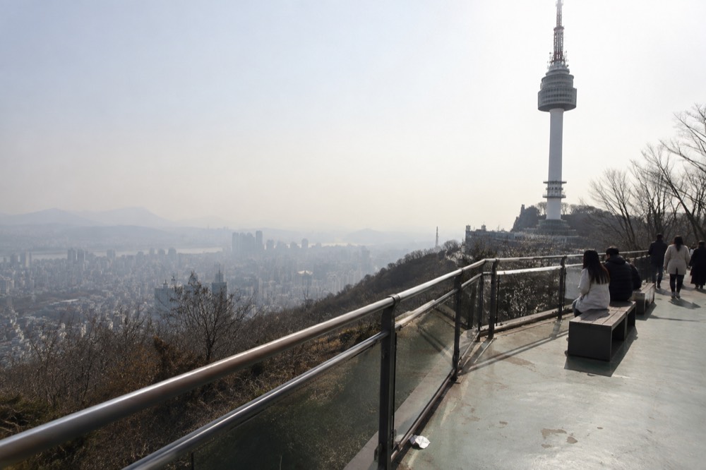Wide terrace walkway on the summit with railings and city views