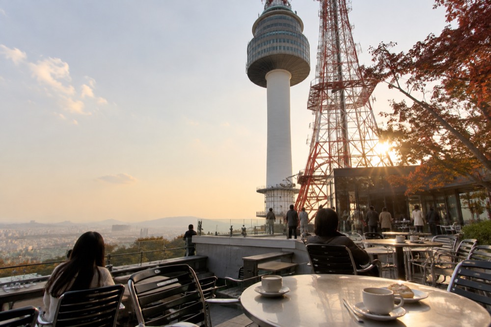Cafe tables on an open terrace with the tower structure rising above