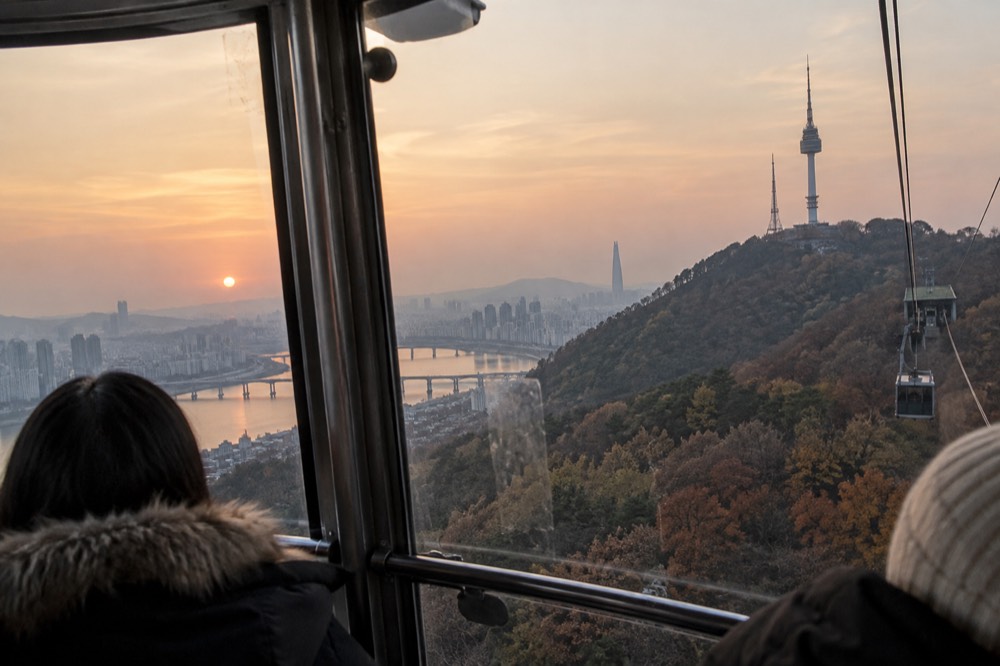 Cable car cabin interior with Seoul cityscape visible through the windows during the ascent
