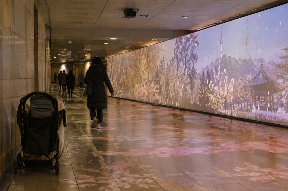 A warmly lit underground cultural passage with an immersive exhibition in central Seoul