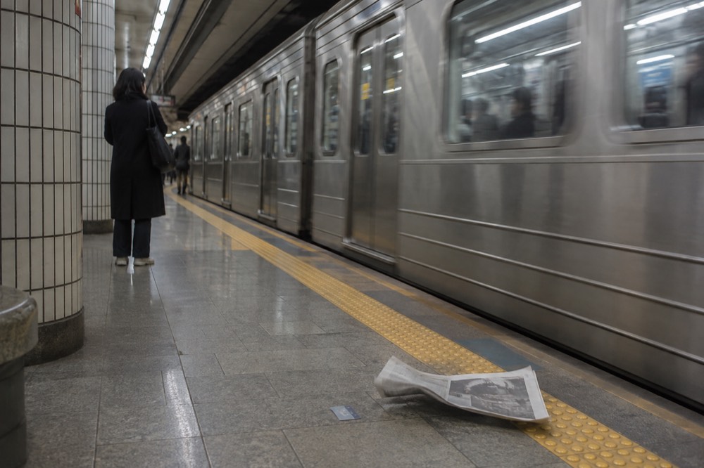 Seoul metro platform with a train arriving and station signage overhead